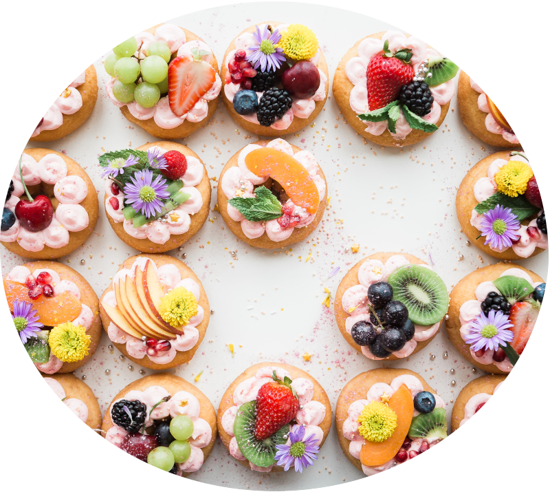 small rounds of cake topped with fresh fruit and colorful flowers